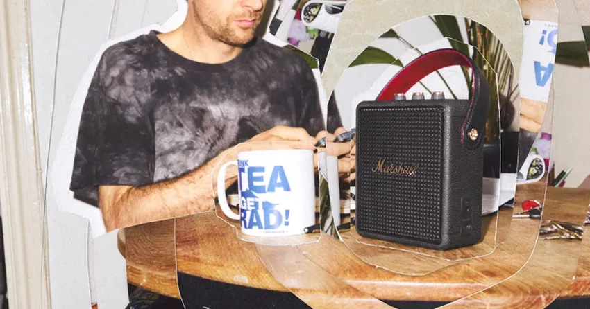Marshall Stockwell III bärbar Bluetooth-högtalare i svart med röda bärhandtag och guldiga kontroller på toppen mot grå bakgrund.